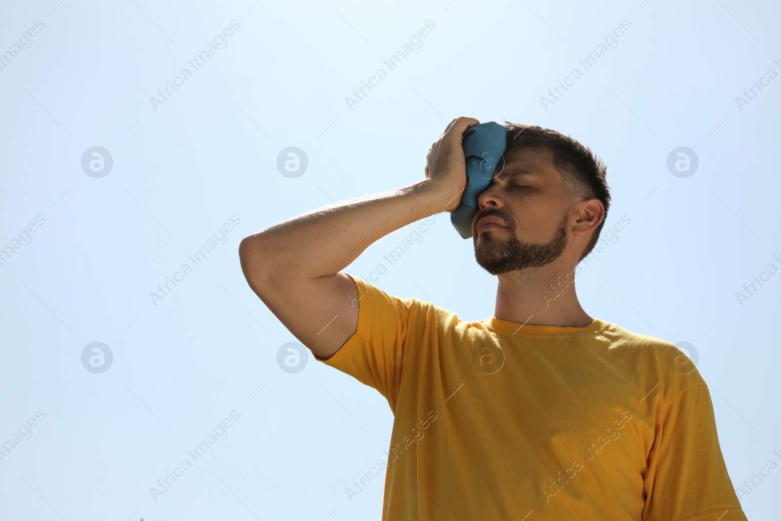 Photo of Man with cold pack suffering from heat stroke outdoors