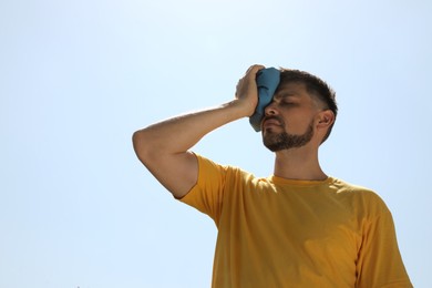 Man with cold pack suffering from heat stroke outdoors