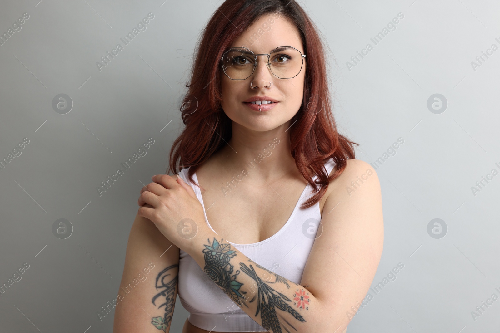 Photo of Portrait of beautiful tattooed woman on gray background