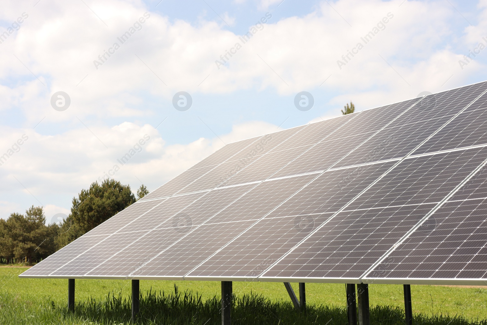 Photo of Solar panels in field on sunny day. Alternative energy