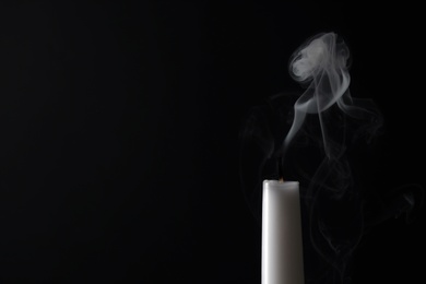 Photo of Smoldering candle wick and smoke on dark background, space for text