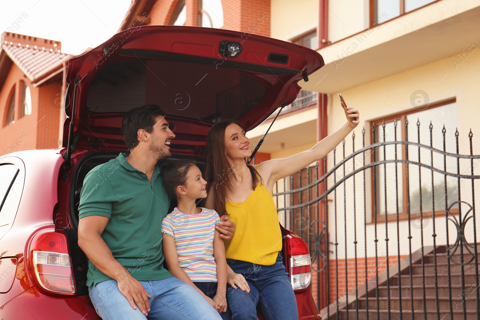 Photo of Happy family taking selfie near car on street