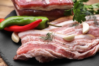 Photo of Pork fatback and ingredients on wooden table, closeup