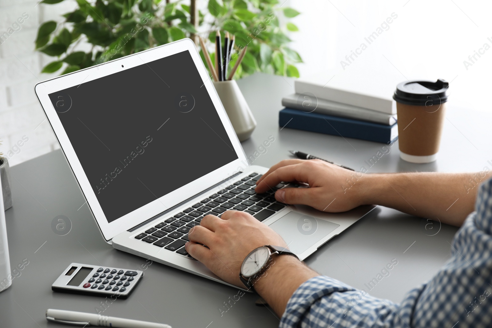 Photo of Man working with laptop at table, closeup. Space for design