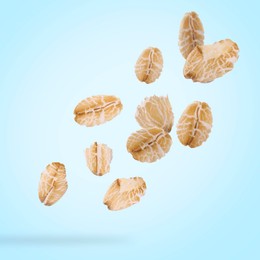 Image of Rolled oat flakes falling on light blue background