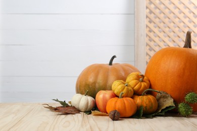 Photo of Happy Thanksgiving day. Pumpkins, autumn leaves and walnut on wooden table. Space for text