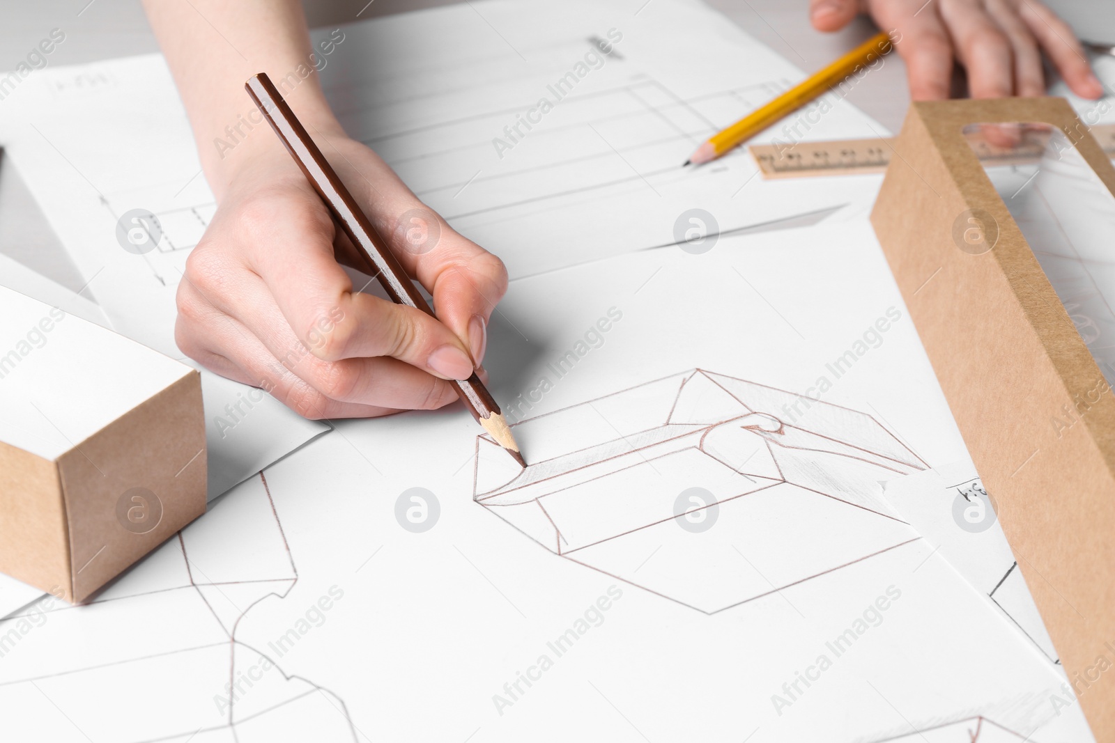 Photo of Woman creating packaging design at table, closeup