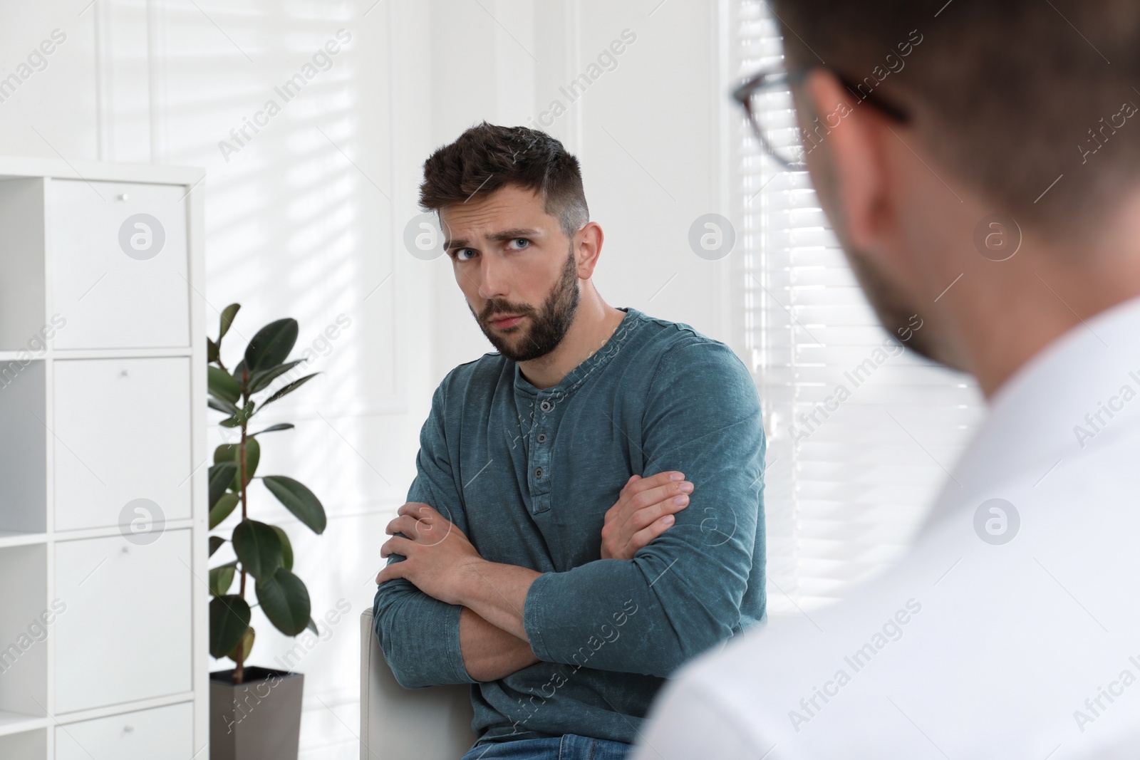 Photo of Psychotherapist working with drug addicted man indoors