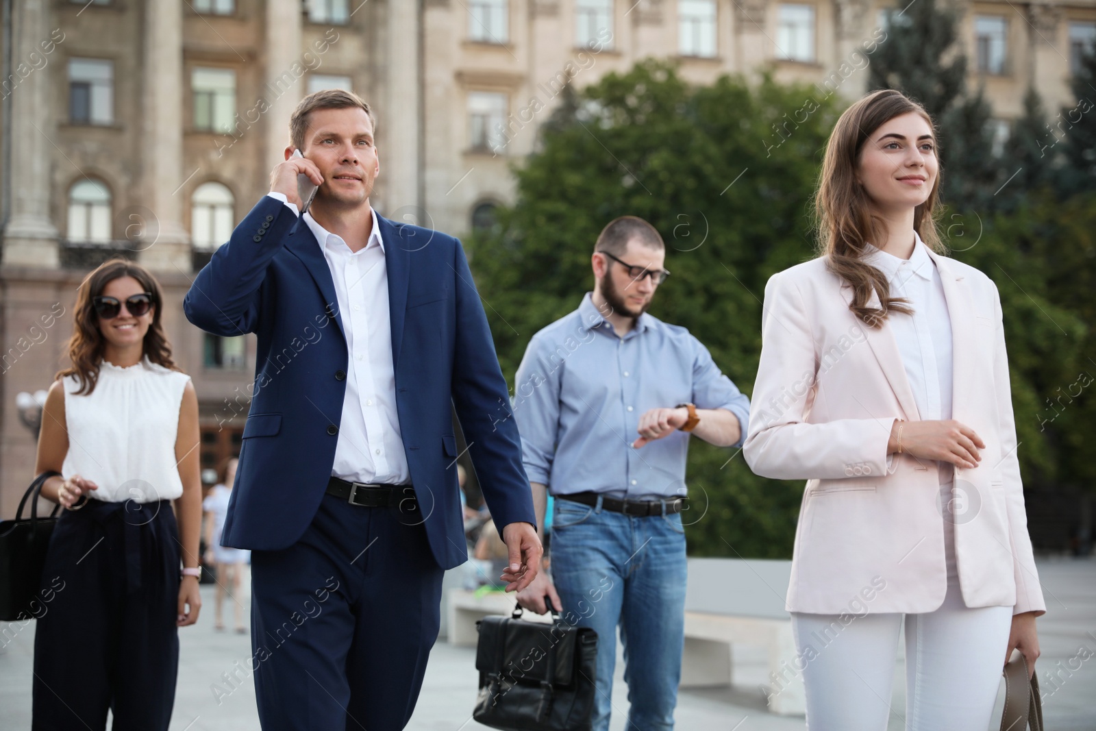 Photo of Different people walking on modern city street