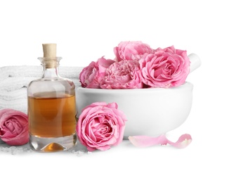 Photo of Spa composition with oil, pink flowers and towels on white background