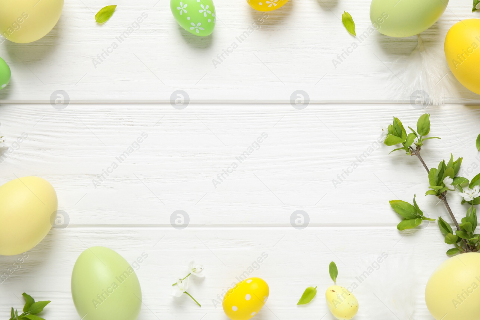 Photo of Frame made with Easter eggs on white wooden background, flat lay. Space for text