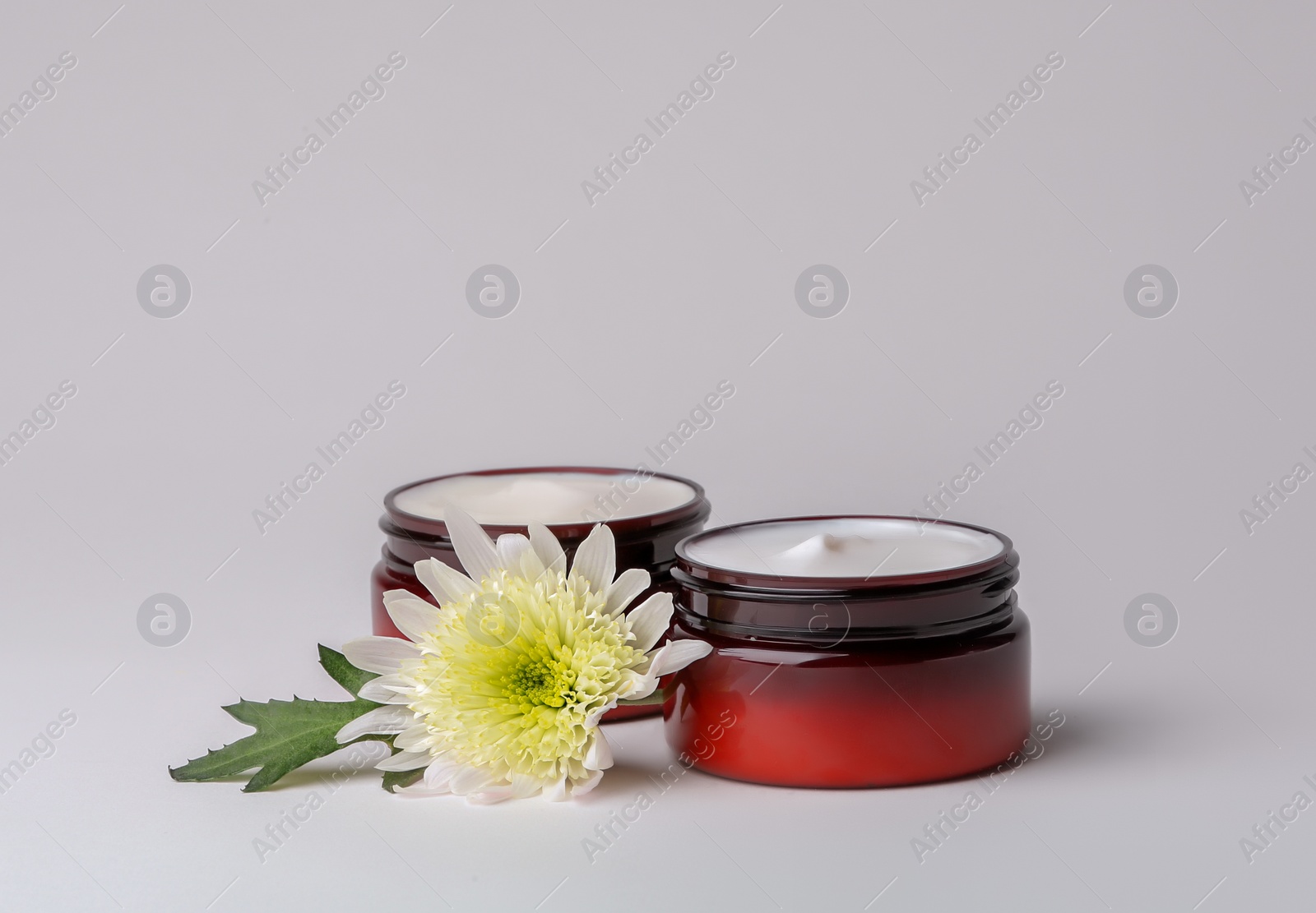 Photo of Jars of body cream on light background