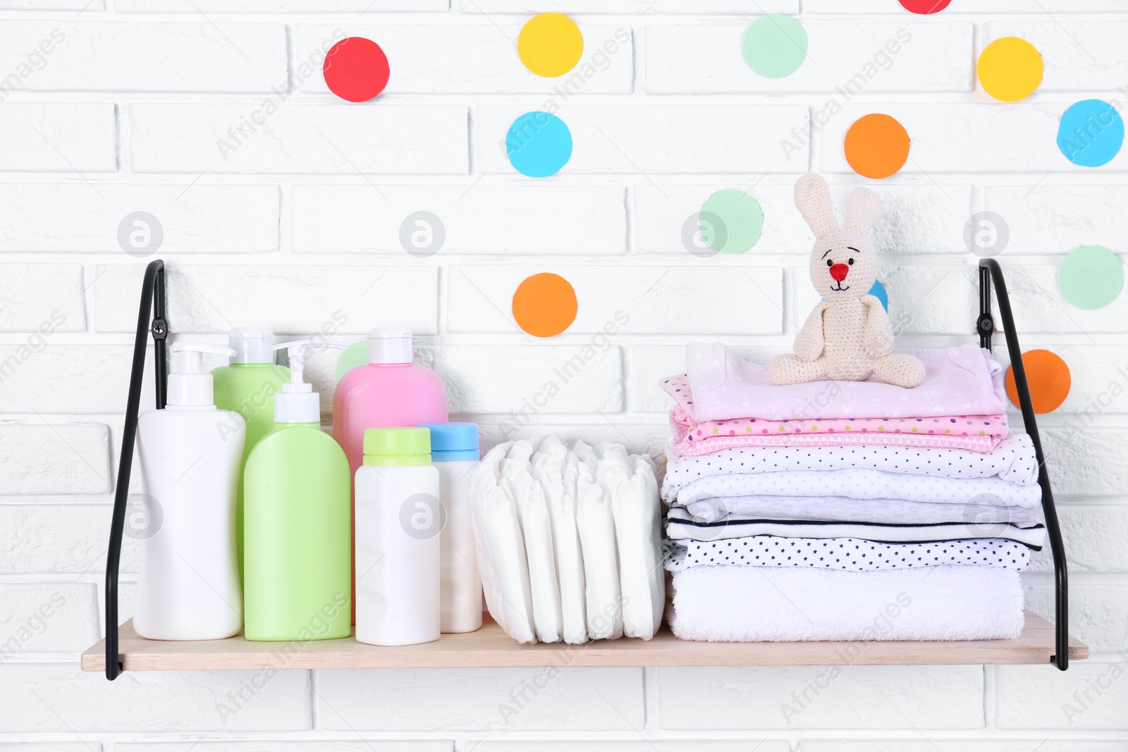 Photo of Baby accessories on shelf near white brick wall