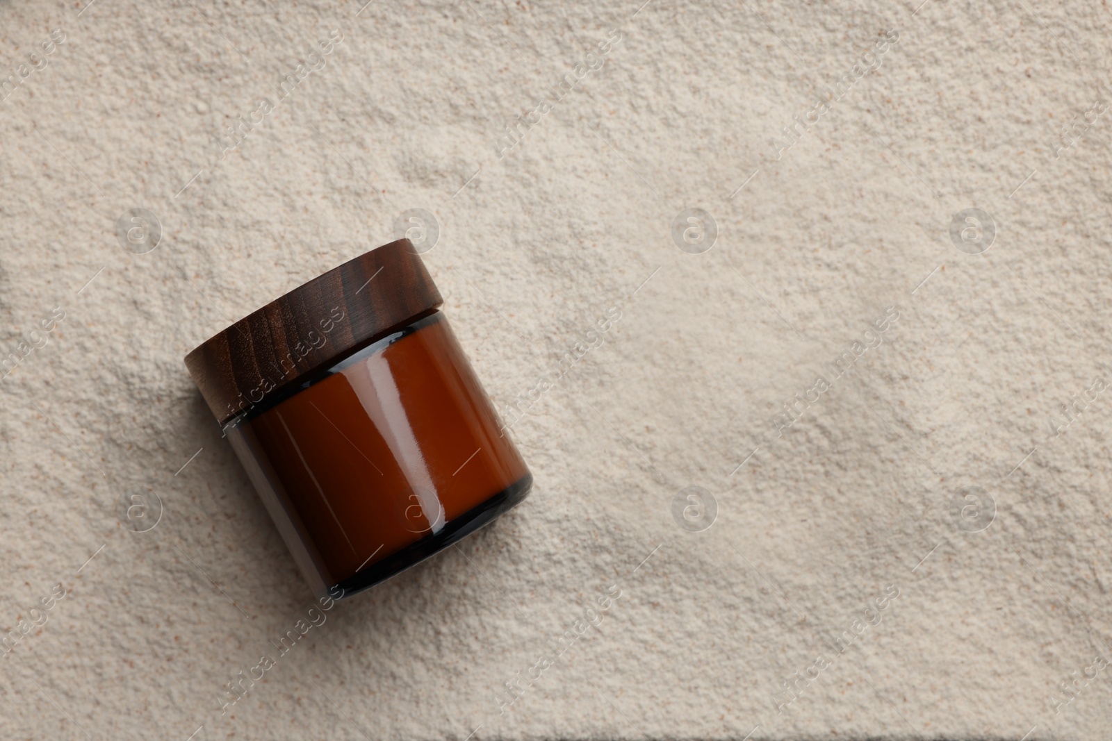 Photo of Glass jar on powder, top view. Space for text