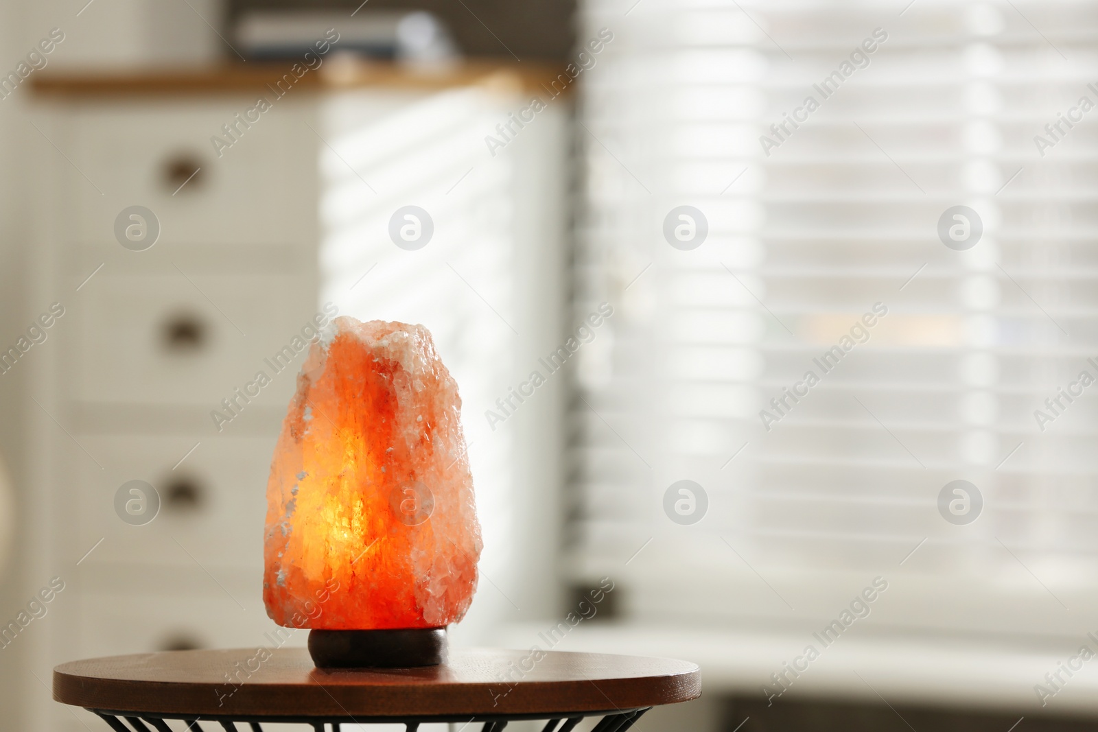 Photo of Himalayan salt lamp on table at home, space for text