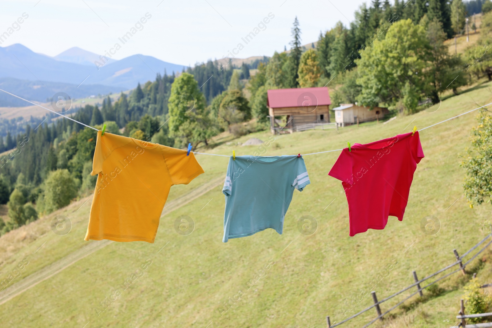 Photo of Washing line with clean laundry and clothespins in mountains