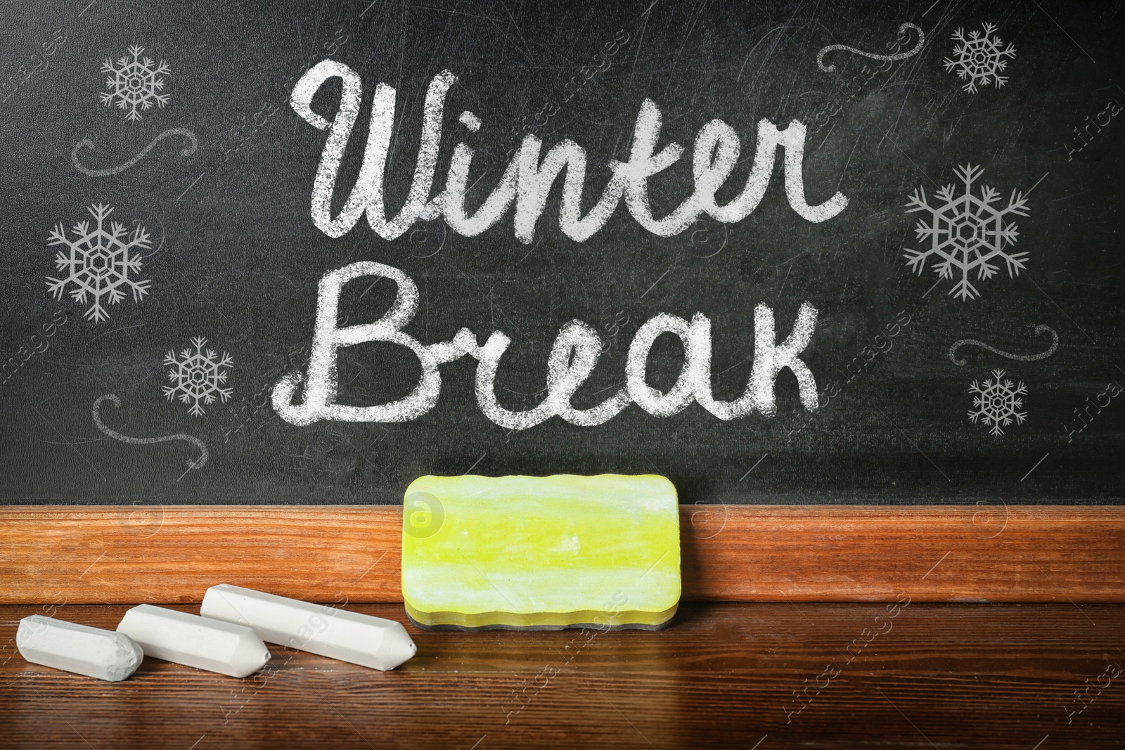 Image of Text Winter break and snowflakes on school blackboard near table with chalk and duster