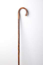 Photo of Elegant wooden walking cane on white background