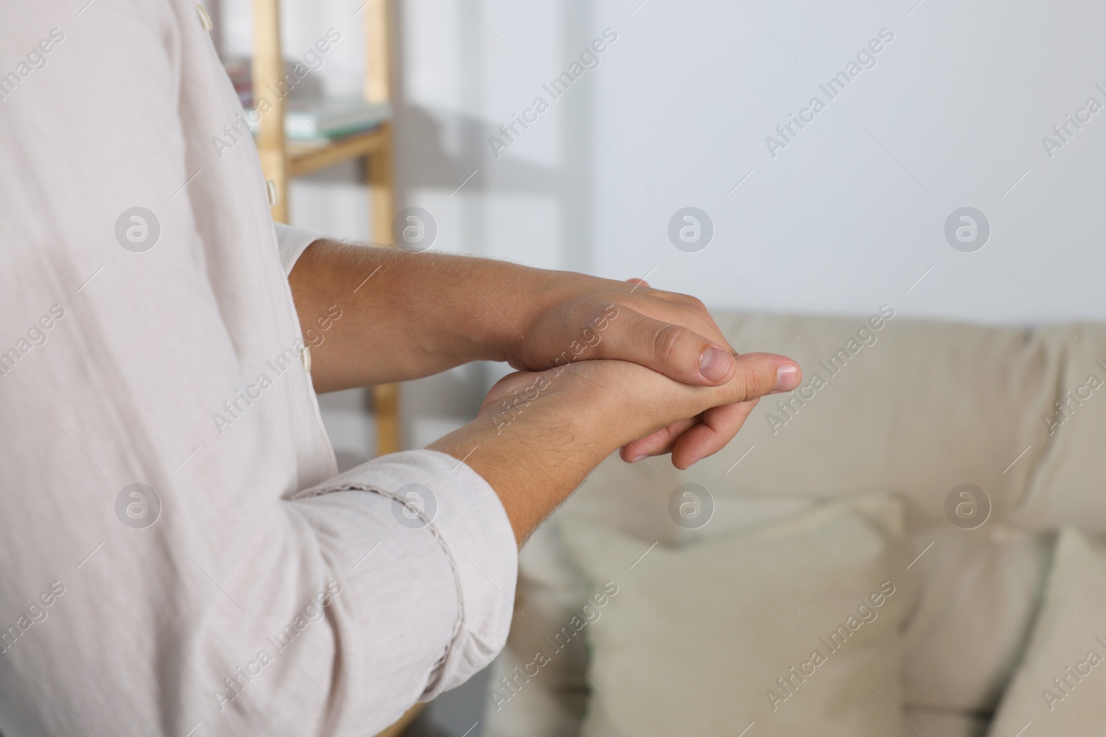 Photo of Man applying hand cream at home, closeup