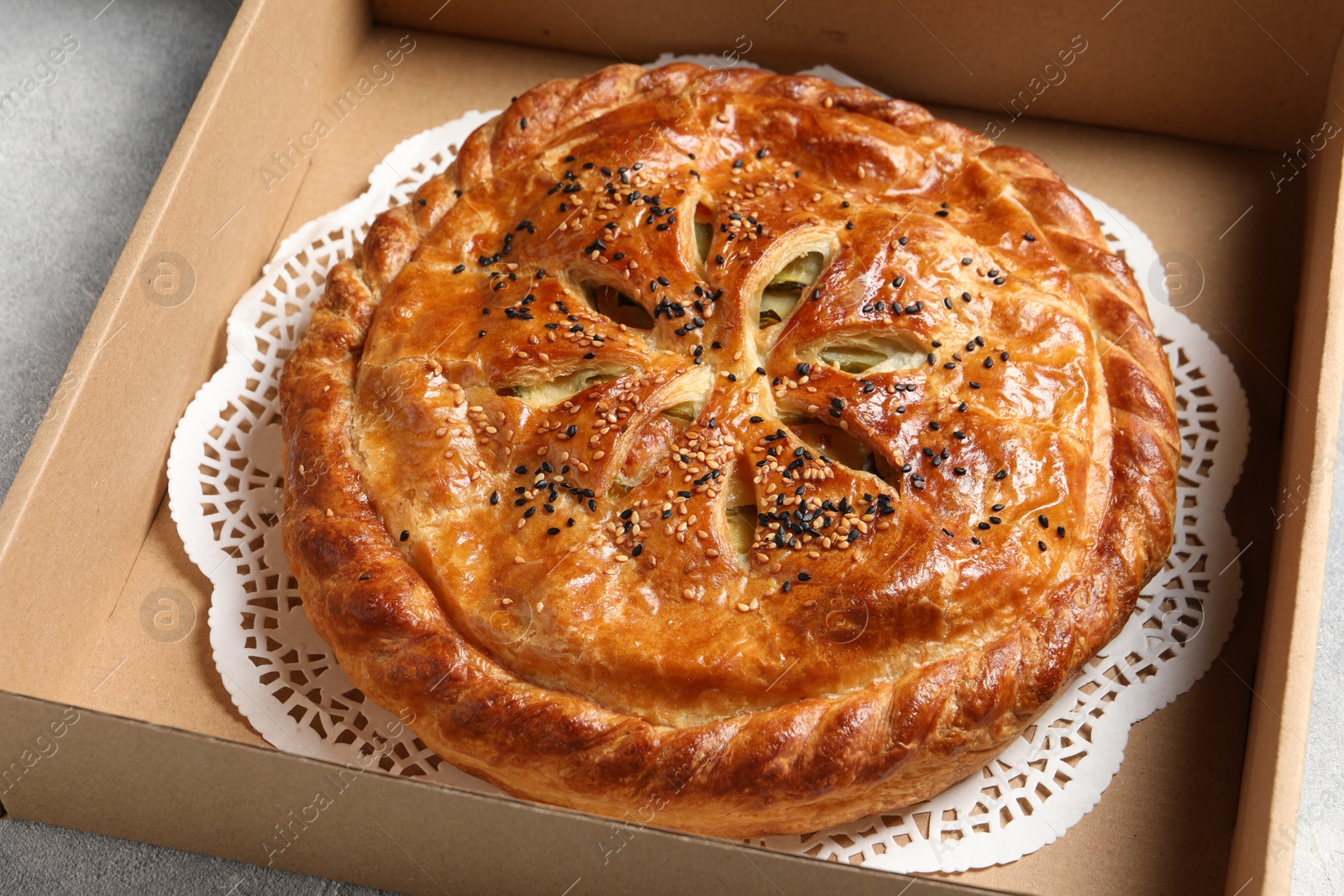 Photo of Tasty homemade pie in box on light table