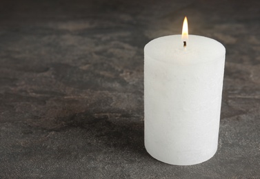 Photo of Alight wax candle on grey background. Space for text