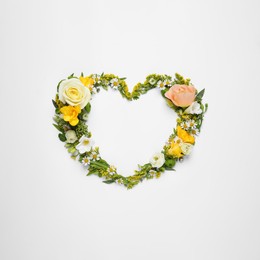 Photo of Beautiful heart made of different flowers on white background, top view