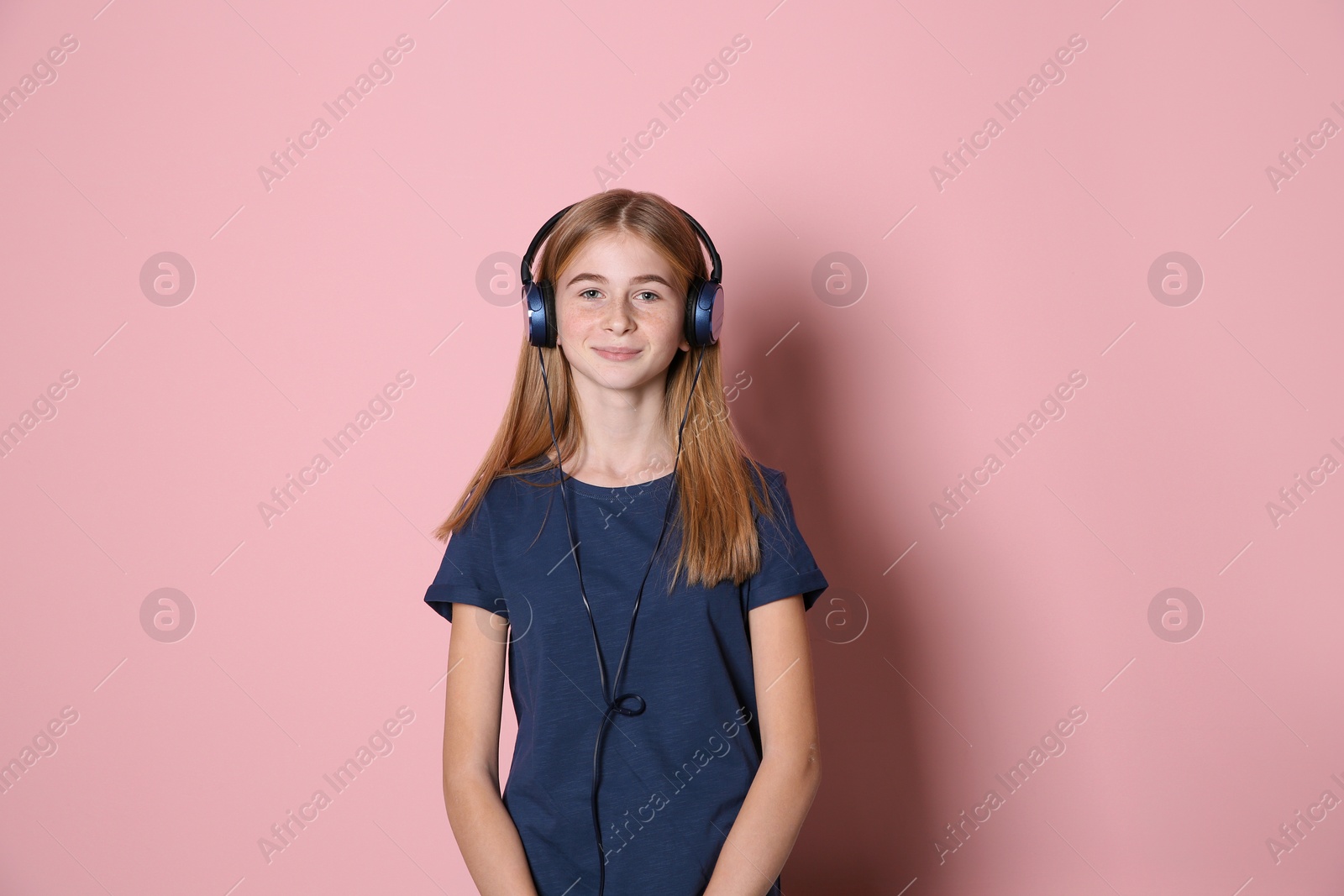 Photo of Teen girl listening to music with headphones on color background