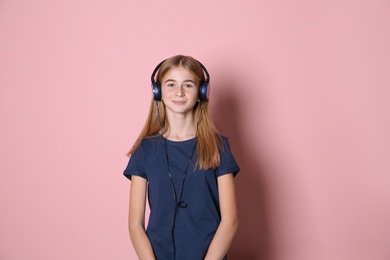 Photo of Teen girl listening to music with headphones on color background