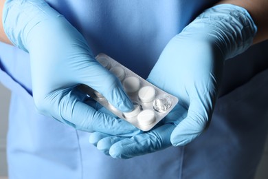 Doctor taking pill out from blister pack, closeup