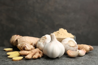 Photo of Ginger and fresh garlic on grey table, space for text. Natural cold remedies