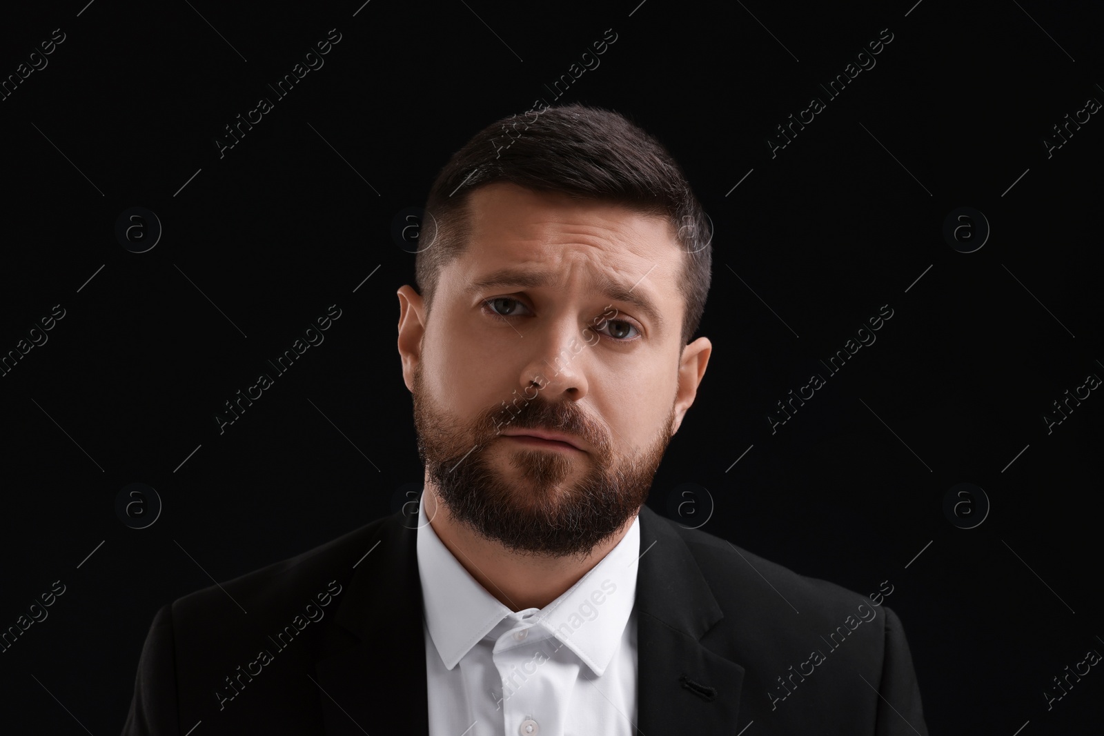Photo of Personality concept. Sad man on black background