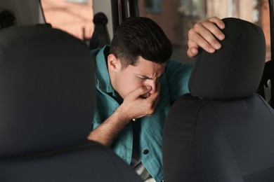 Photo of Man suffering from nausea in his car