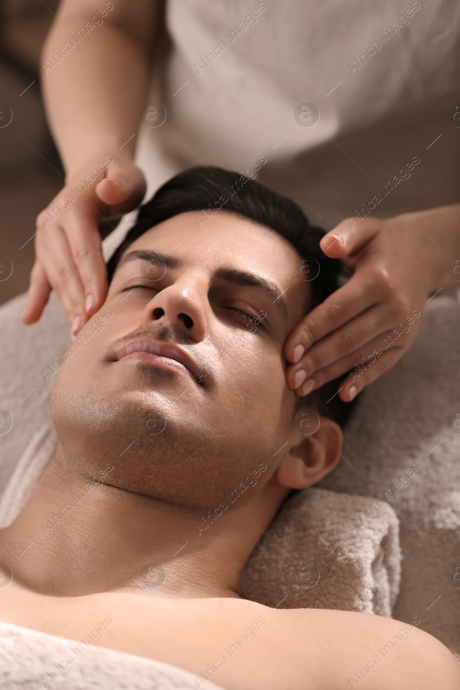 Photo of Man receiving facial massage in beauty salon