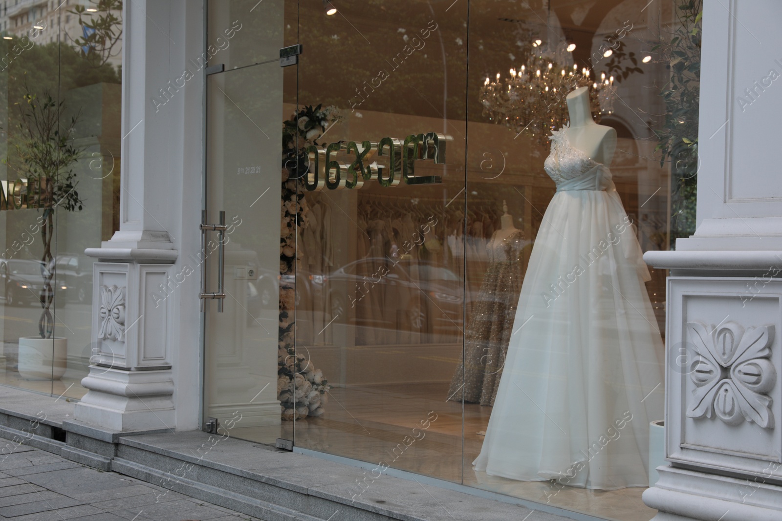 Photo of Showcase with beautiful wedding dress on mannequin