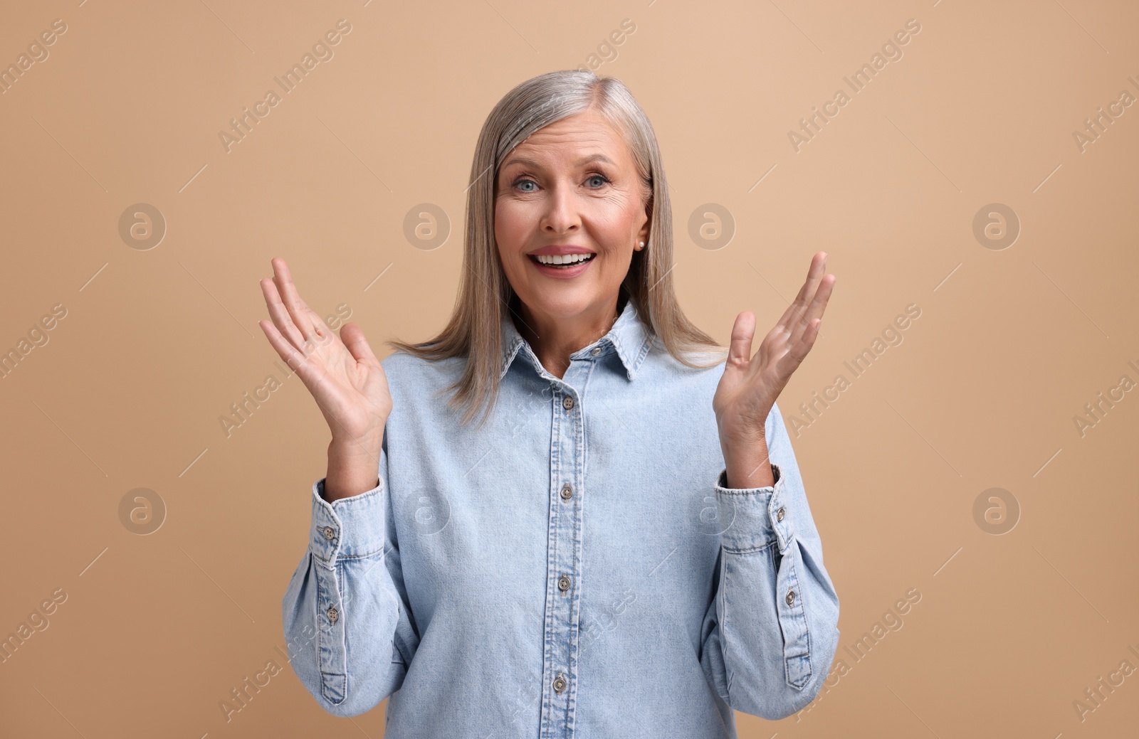 Photo of Portrait of emotional middle aged woman on beige background