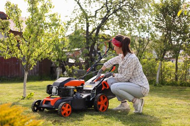 Photo of Woman with lawn mower in garden on sunny day