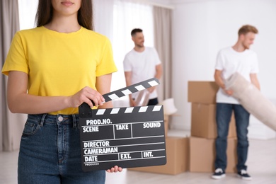 Photo of Operator holding clapperboard during the production indoors, closeup