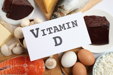 Photo of Paper with phrase VITAMIN D and fresh products on white background