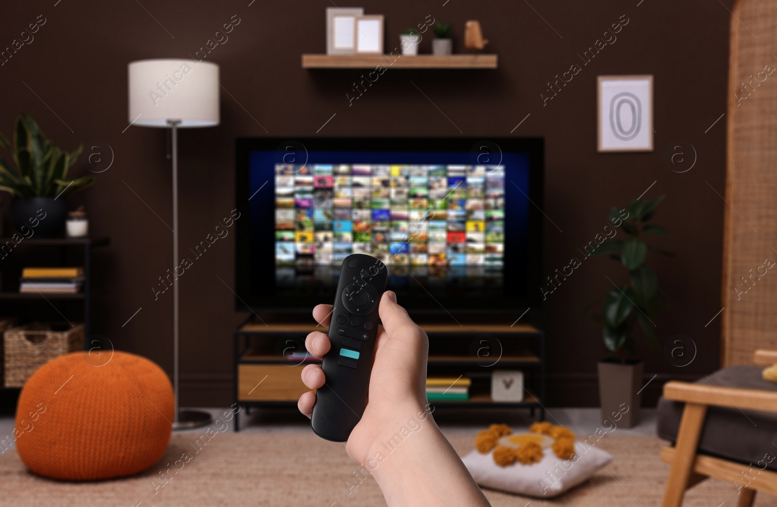 Image of Woman with remote control changing channels while watching TV at home, closeup