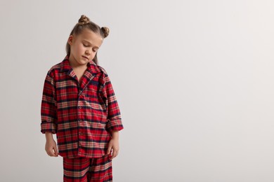 Girl in pajamas sleepwalking on white background, space for text