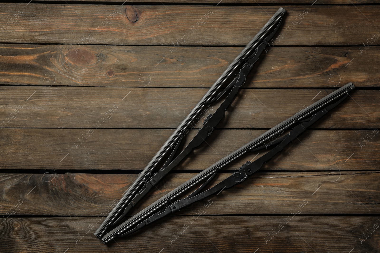 Photo of Car windshield wipers on wooden background, flat lay. Space for text
