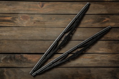 Car windshield wipers on wooden background, flat lay. Space for text