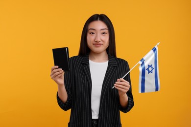 Immigration to Israel. Woman with passport and flag on orange background