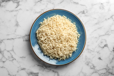 Photo of Plate of tasty noodles on marble background, top view