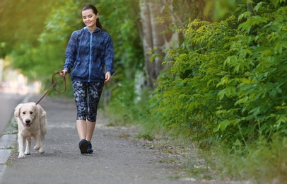 Young woman with her dog together in park. Pet care