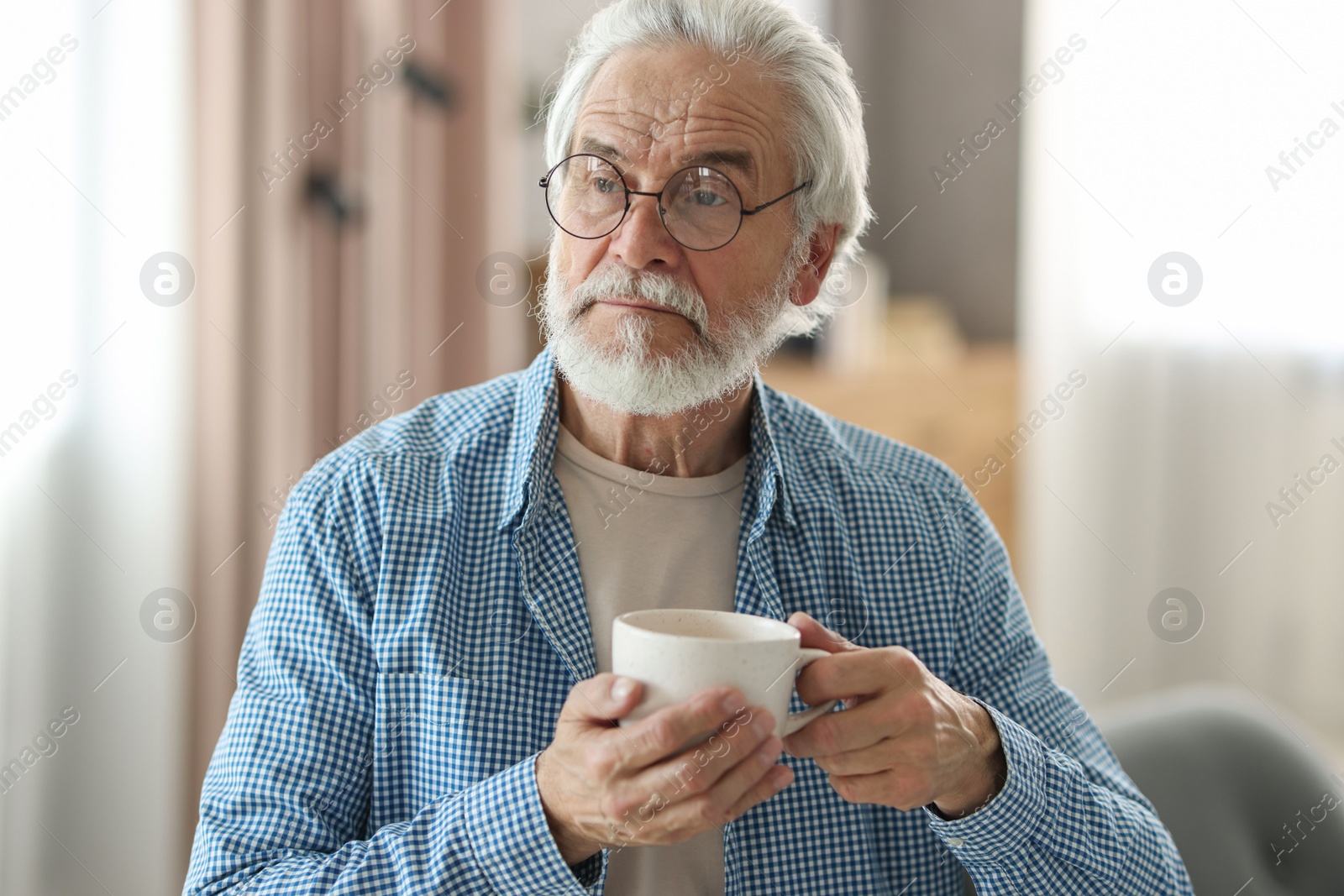 Photo of Portrait of happy grandpa with glasses and cup of drink indoors