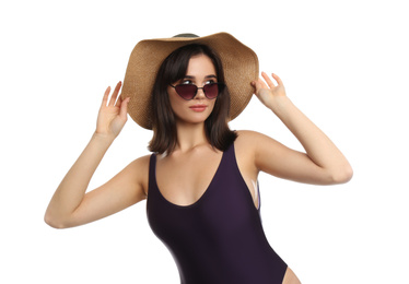 Beautiful young woman wearing swimsuit, hat and sunglasses on white background
