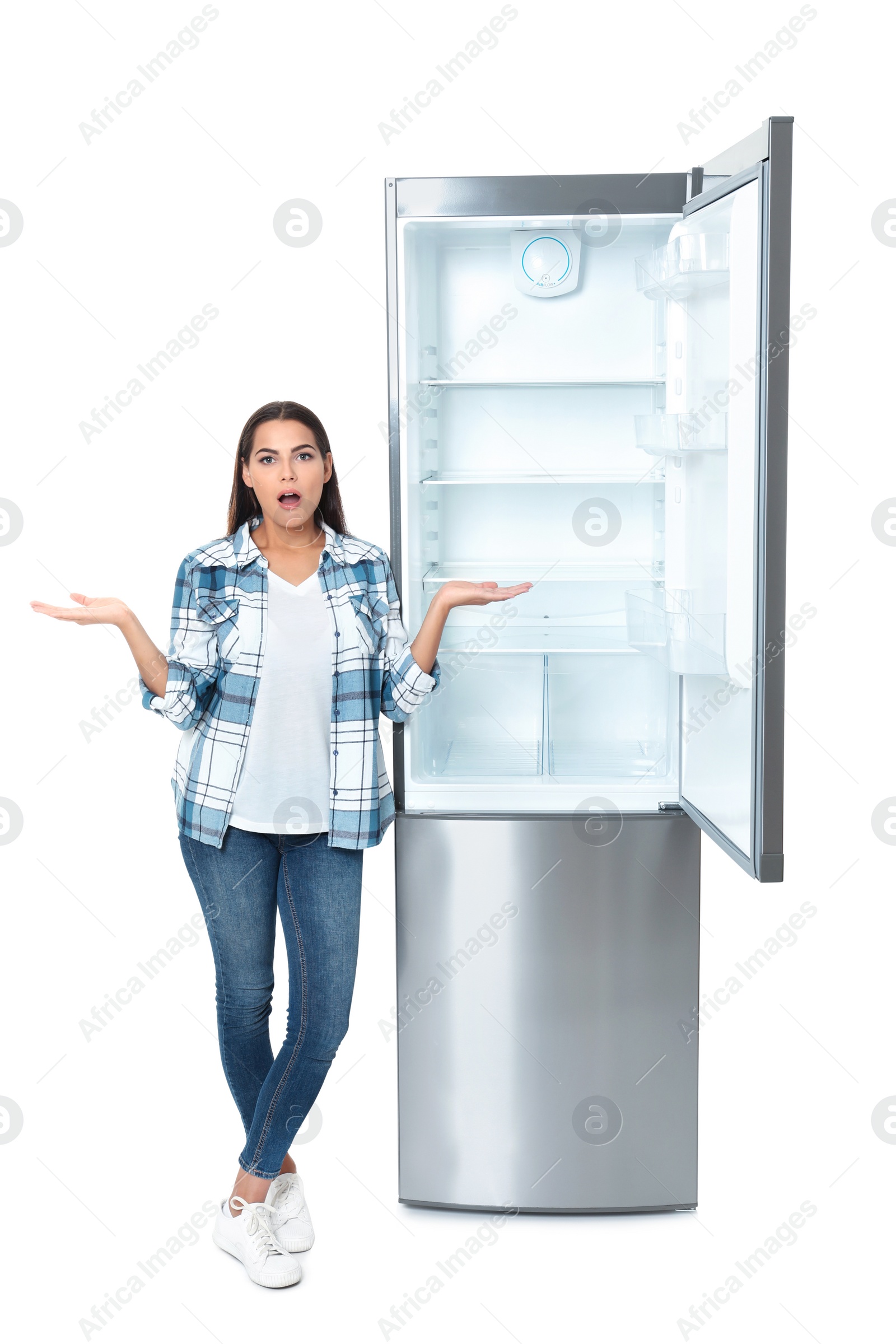 Photo of Emotional woman near empty refrigerator on white background