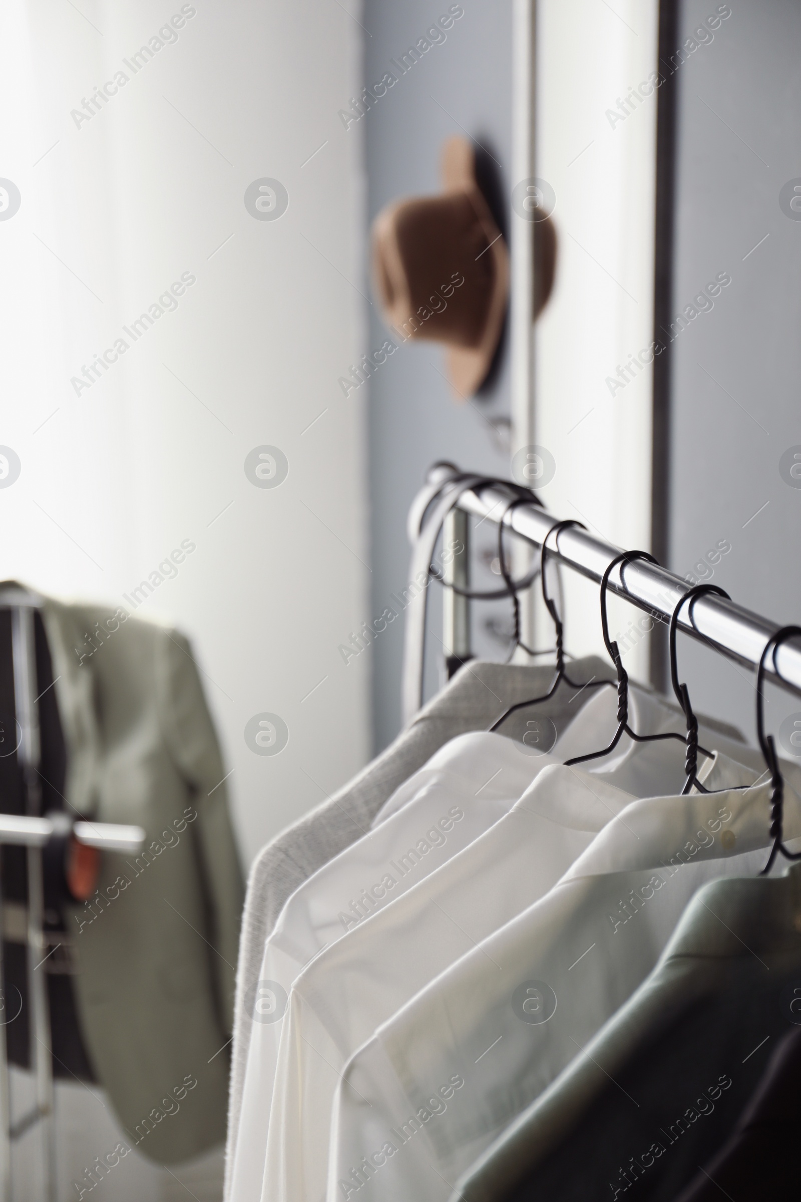 Photo of Rack with stylish men's clothes indoors, closeup. Interior design