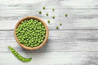 Flat lay composition with green peas on wooden background